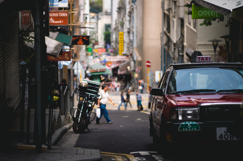 红停车场近大厦路边|中心,交通系统,人,人行道,出租车,商业,城市,建筑物,户外,日光,汽车,红色,自行车,行动,街道,购物,车辆,道路-海量高质量免版权图片素材-设计师素材-摄影图片-mitapix-美塔图像