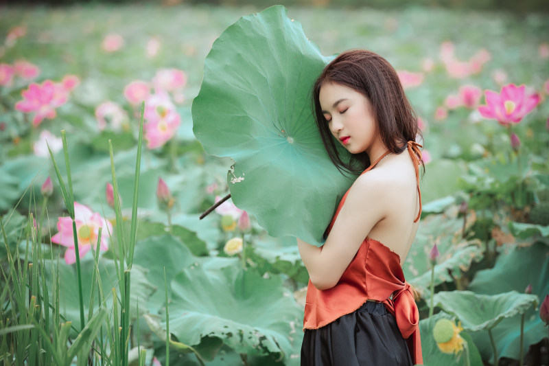 一个戴挂脖上衣拿着树叶的女人|人,可爱的,叶子,女人,女孩,时尚的,植物,漂亮的,美丽的,花,衣服-海量高质量免版权图片素材-设计师素材-摄影图片-mitapix-美塔图像