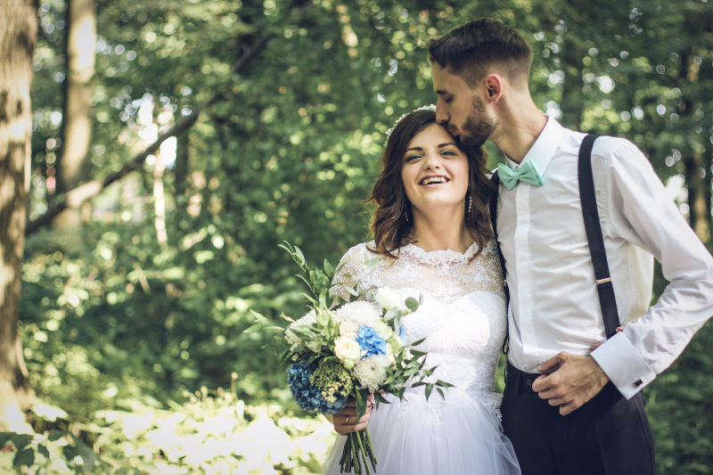 新郎亲吻新娘附近的树木Groom Kissing Bride Near Trees|adult,affection,Blur,bouquet,bridal,bride,Celebration,Close-up,couple,dress,Fashion,Focus,forest,formal,girl,groom,happiness,Happy,in love,kiss,love,Man,marriage,model,nature,outdoors,Park,People,photoshoot,romance,romantic,together,togetherness,Trees,wedding,wedding dress,woman,woods,之一,亲亲,人,公园,团结,在一起,夫妇,女人,女孩,婚姻,婚礼,婚纱,幸福,庆祝活动,快乐,恋爱,感情,成人,户外,拍摄,新娘,新郎,时尚,服饰,树木,树林,森林,模型自然,模糊,正式,浪漫,焦点,爱情,特写,花束-海量高质量免版权图片素材-设计师素材-摄影图片-mitapix-美塔图像