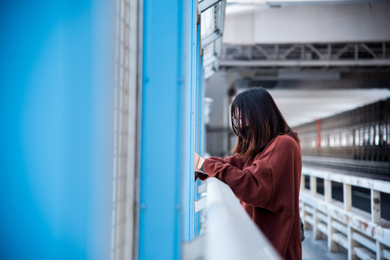 一个穿红毛衣的女人倚在白色的铁栏杆上|交通系统,人,侧视图,城市,女孩,妇女,室内,建筑,成人,旅游,服装,桥梁,模糊,独自-海量高质量免版权图片素材-设计师素材-摄影图片-mitapix-美塔图像