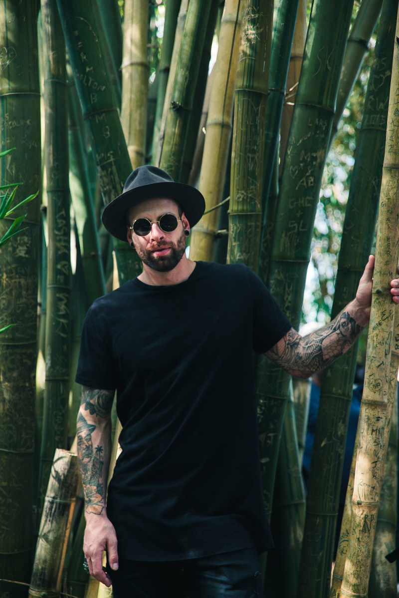 男人拿着竹植物戴着墨镜和Fedora的帽子Man Holding Bamboo Plant Wearing Sunglasses and Fedora Hat|人,在户外,太阳镜,娱乐,成人,拍的,旅行,时尚,构成,模型,男人,穿,竹子,竹树,纹身,肖像,艺术,英俊的,街,黑色T恤-海量高质量免版权图片素材-设计师素材-摄影图片-mitapix-美塔图像