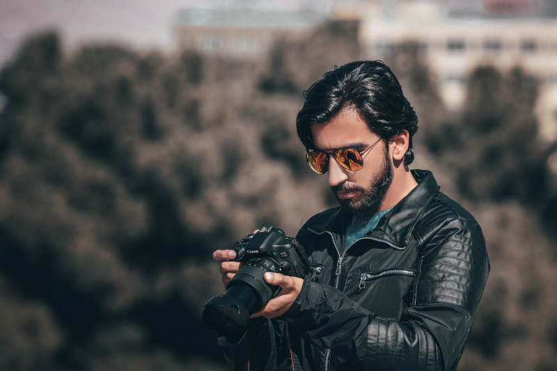 选择性焦点摄影的人持有Dslr相机Selective Focus Photography of Man Holding Dslr Camera|adult,beard,black leather jacket,Blur,boy,Camera,capture,closeup,eyewear,facial hair,Fashion,finelooking,Focus,guy,hair,handsome,leather jacket,male,Man,model,outdoors,person,photographer,photoshoot,sunglasses,wear,人,太阳镜,头发,好看,家伙,成人,户外,拍摄图片,捕获,摄影师,时尚,模型,模糊,焦点,特写,男,男子,男孩,皮夹克,相机,眼镜,穿,胡子,英俊,面部毛发,黑色皮夹克-海量高质量免版权图片素材-设计师素材-摄影图片-mitapix-美塔图像