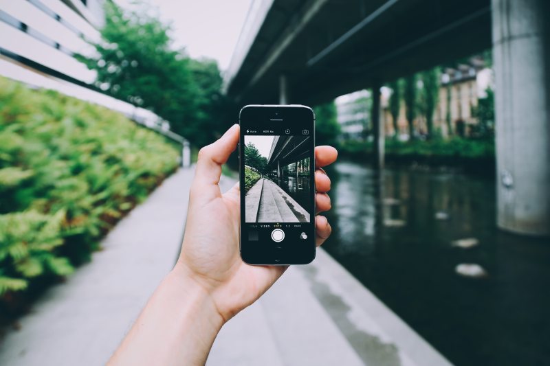 使用太空灰iPhone摄像头的人|交通系统,人,城市,建筑,户外,手,手机,技术,握,摄影,旅游,日光,智能手机,桥梁,模糊,水,照相机,生活方式,电子,白天,移动,街道,设备,道路-海量高质量免版权图片素材-设计师素材-摄影图片-mitapix-美塔图像