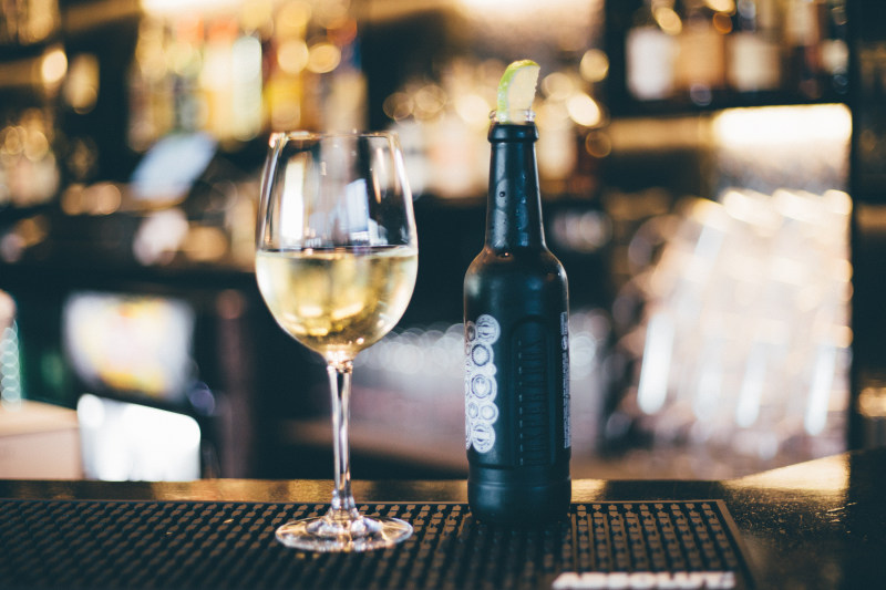 黑色长茎旁的酒瓶酒杯表Black Bottle Beside Long-stem Wine Glass on Table|喝,在室内,玻璃,瓶,表,计数器,酒吧-海量高质量免版权图片素材-设计师素材-摄影图片-mitapix-美塔图像