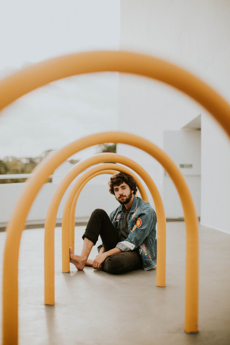 男子坐在黄色拱户外Man Sitting on Yellow Arch Outdoor|barefoot,beard,blurred background,casual,Colors,Daylight,daytime,eyes,face,facial expression,facial hair,Fashion,fashionable,guy,hair,hairstyle,Hands,human,landscape,lips,looking,male,male model,Man,model,outdoors,outerwear,outfit,person,photoshoot,pose,posing,skin,wall,wear,Young,young man,Youth,之一,人,人类,休闲,发型,嘴唇,墙,外套,头发,家伙,寻找,年轻,年轻人,户外,手,拍摄,时尚,景观,服装,构成,模型,模糊背景,男性,男性模型,白天,皮肤,眼睛,穿,胡子,脸,赤脚,青年,面部毛发,面部表情,颜色-海量高质量免版权图片素材-设计师素材-摄影图片-mitapix-美塔图像