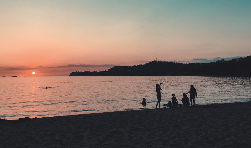 人们站在海边，坐在海边|人,傍晚,夕阳,太阳,户外,斑点,水,沙,波浪,海景,海洋,海滨,海滩,游泳,轮廓,金色的夕阳,风景,黄昏-海量高质量免版权图片素材-设计师素材-摄影图片-mitapix-美塔图像