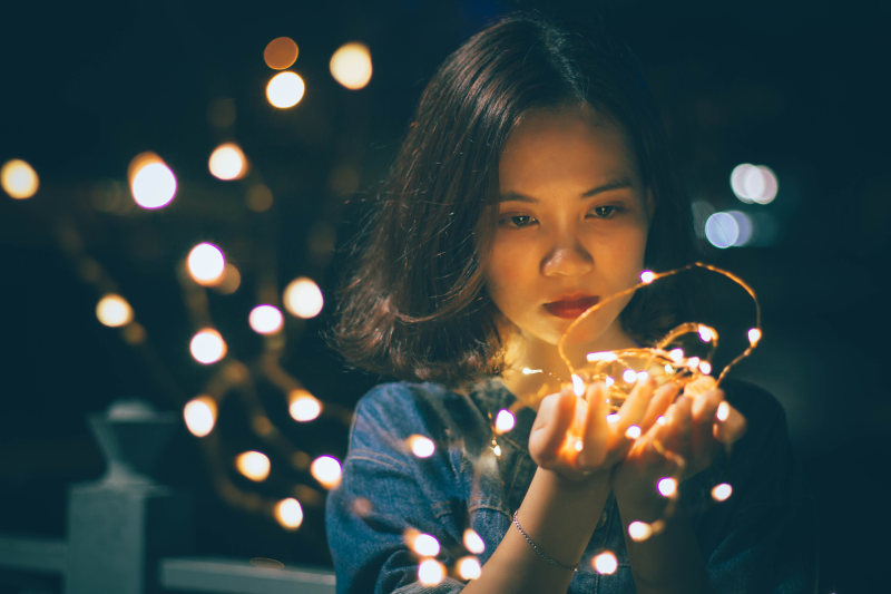 近距离拍摄拿着刺灯的女人|串线灯,博客,圣诞灯,女人,女孩,女性,庆祝,悲伤,摄影,明亮,景深,模特,模糊,灯光,焦点,照明,特写,美丽,肖像,脸部,面部表情-海量高质量免版权图片素材-设计师素材-摄影图片-mitapix-美塔图像