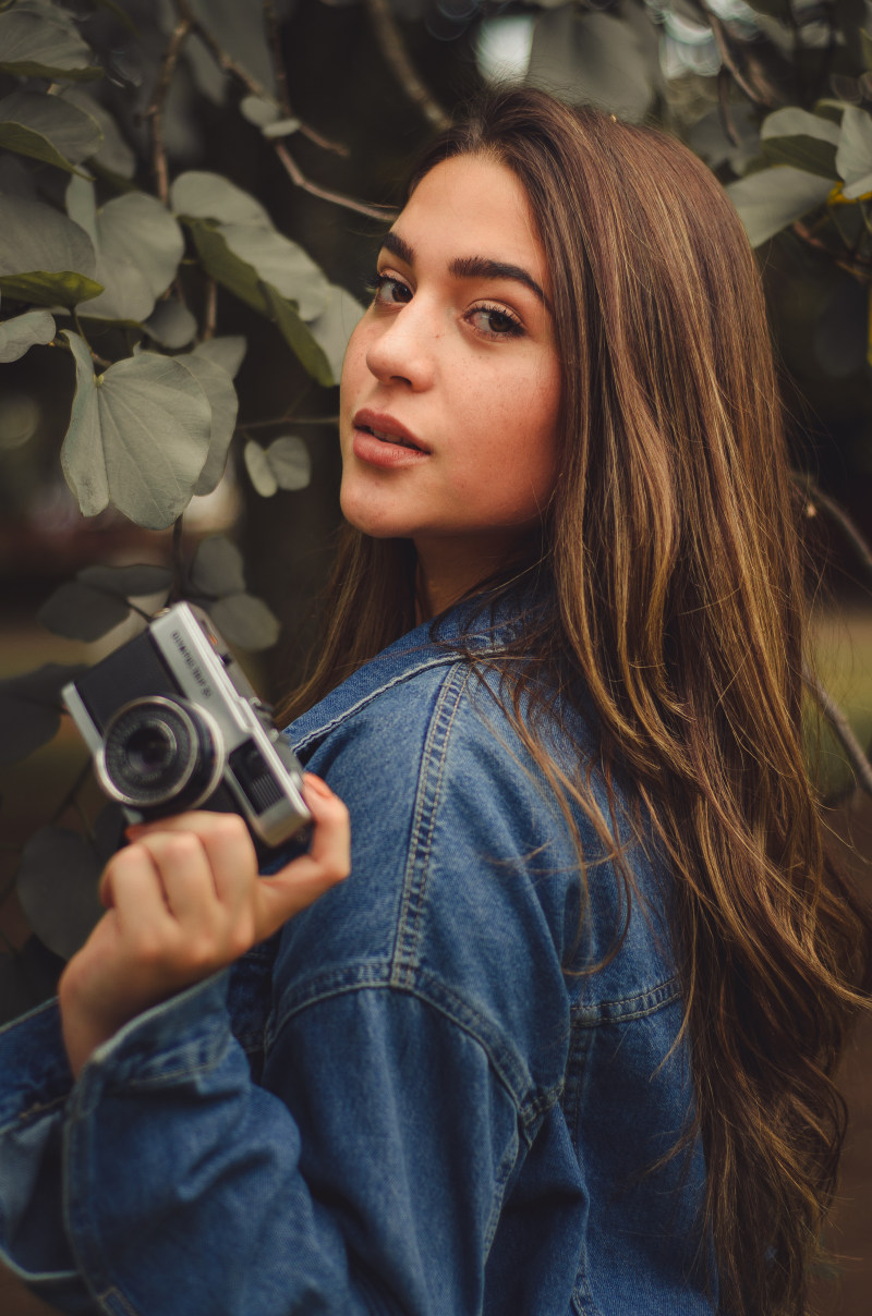 穿蓝色牛仔夹克的妇女，当拿着照相机在树附近Woman Wearing Blue Denim Jacket While Holding Camera Near Tree|Beautiful,Camera,closeup,Cute,eyes,face,facial expression,holding,pose,posing,pretty,wear,woman,举行,俏丽,妇女,姿势,摆在,照相机,特写镜头,眼睛,穿戴,美丽,表情,逗人喜爱,面孔-海量高质量免版权图片素材-设计师素材-摄影图片-mitapix-美塔图像