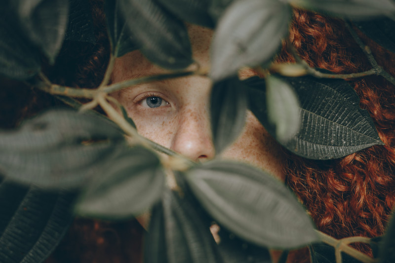 特写照片背后的人离开了Close-Up Photo of Person Behind Leaves|人,卷发,叶子,女,女孩,景深,模糊,焦点,特写镜头,的脸,看,眼睛,红色头发的人,蓝色的眼睛,隐藏-海量高质量免版权图片素材-设计师素材-摄影图片-mitapix-美塔图像