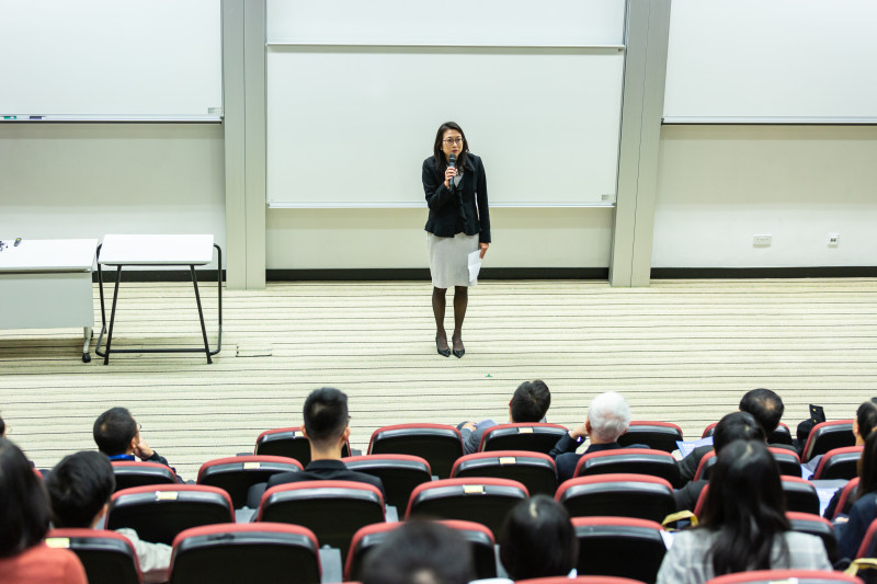 女人拿着麦克风站在人群的前面Woman Holding Microphone Standing in Front of Crowd-人,会议,在室内,坐着,女人,家具,教室,桌子上,椅子,穿,类,表,讲座,集团,麦克风-海量高质量免版权图片素材-设计师素材-摄影图片-mitapix-美塔图像