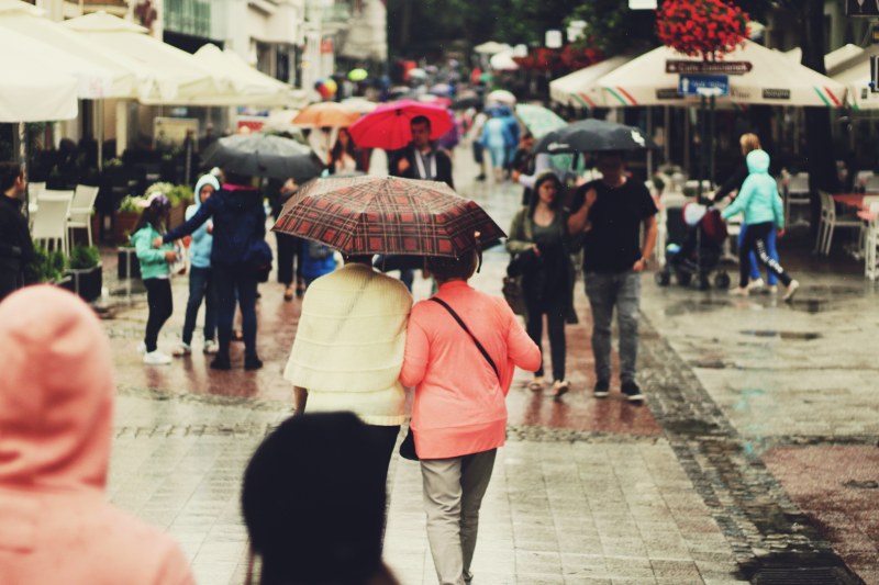 人们拿着雨伞走在胡同里|下雨,人,人群,人行道,公众,商店,城市,城镇,市中心,市场,帐篷,户外,旅游,日光,步行,游客,街道,道路,雨伞-海量高质量免版权图片素材-设计师素材-摄影图片-mitapix-美塔图像