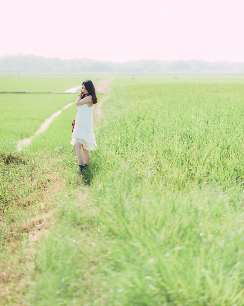 一个穿着白色衣服的女人站在绿油油的草地上|乡村,人,农场,女孩,年轻人,户外,田野,白天,白色衣服,草地,风景-海量高质量免版权图片素材-设计师素材-摄影图片-mitapix-美塔图像